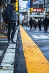 街頭男子佇立在黃色盲道旁